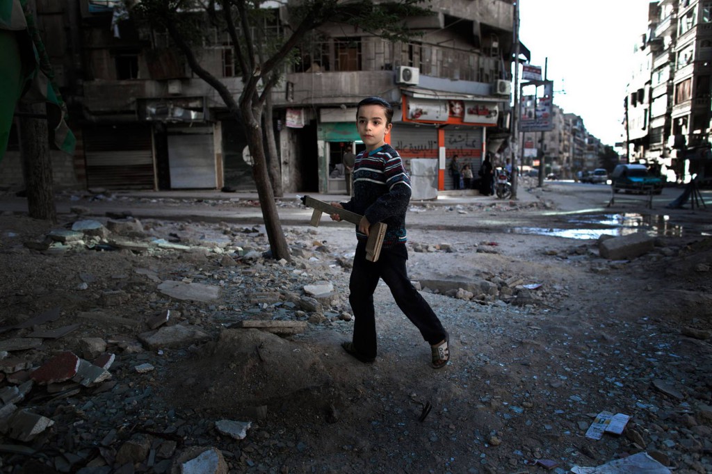 En ung pojke leker med ett hemmagjort leksaksgevär i Aleppo. Foto: NICLAS HAMMARSTRÖM